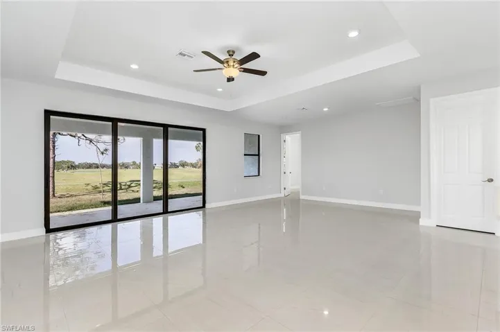 Unfurnished room with ceiling fan, a raised ceiling, and light tile patterned floors