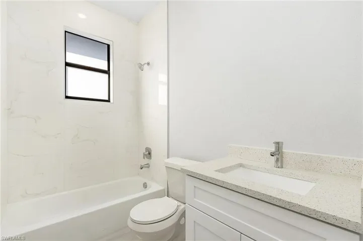 Full bathroom featuring toilet, tiled shower / bath, and vanity
