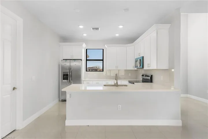 Kitchen featuring stainless steel appliances, light tile patterned floors, and tasteful backsplash