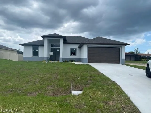 Prairie-style house with a garage and a front lawn