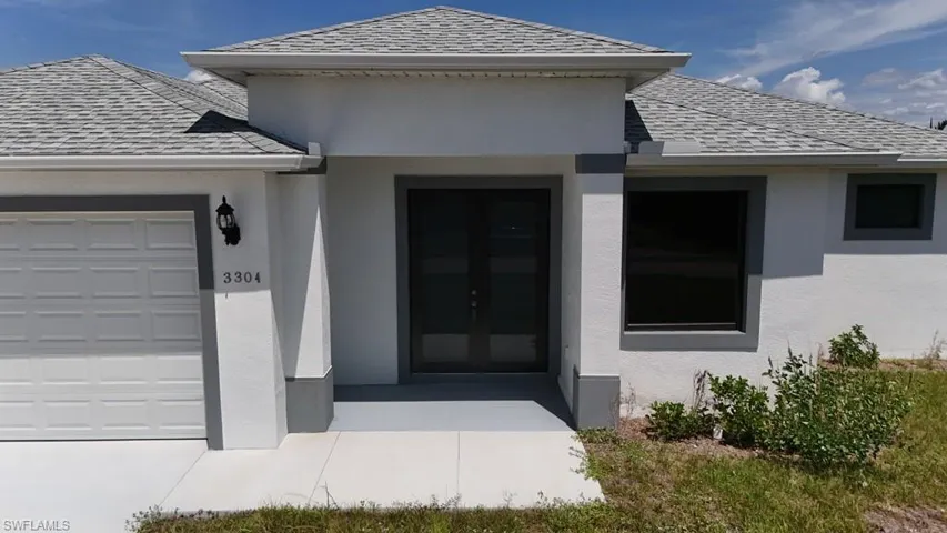 Contemporary stucco exterior featuring a dual entry door, a single-panel garage door, crisp white trim, and a shingled roof