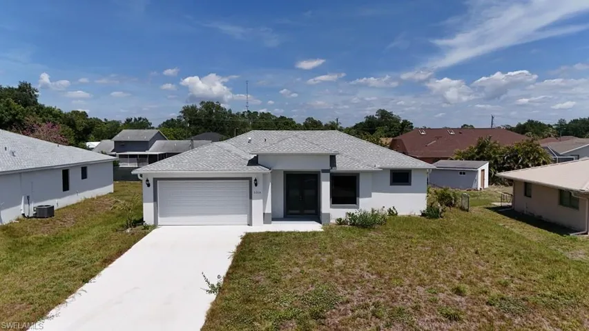 Modern single-story residence featuring a light-colored exterior with dark trim accents