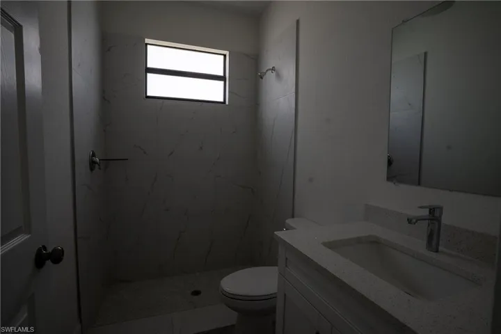 Bathroom featuring a white vanity with an integrated sink, polished chrome faucet, and a wall-mounted mirror