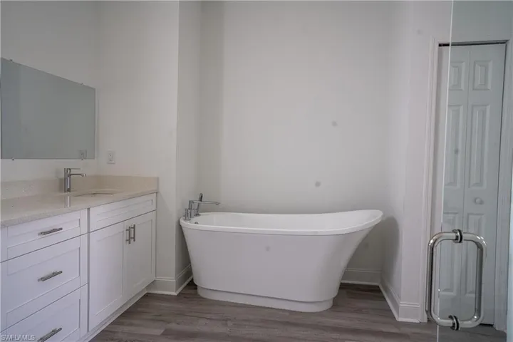 Freestanding soaking tub complemented by a double vanity with stone countertops