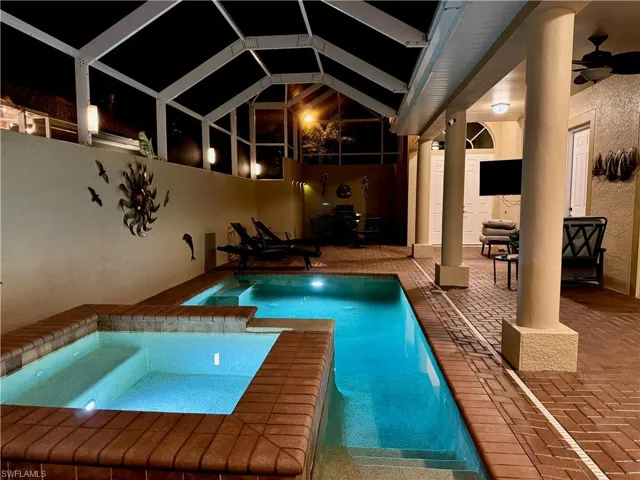 View of pool the covered patio in front of the family room
