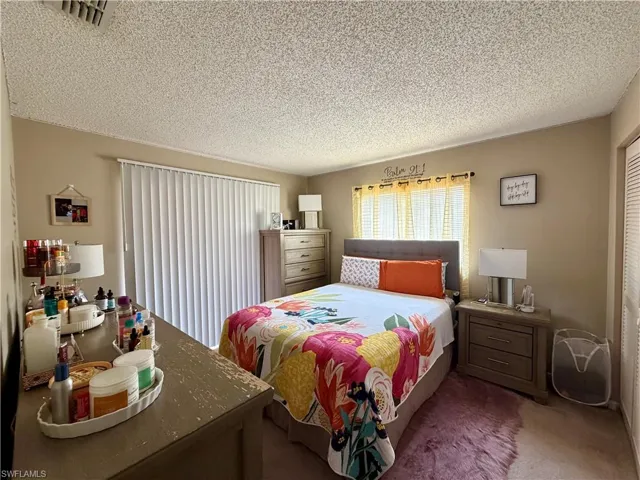 19209 - Carpeted bedroom with a textured ceiling and a closet