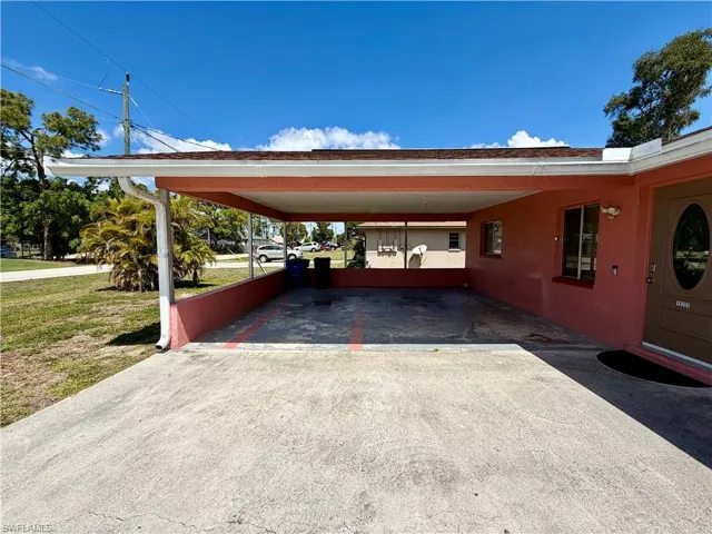 View of parking featuring driveway and an attached carport