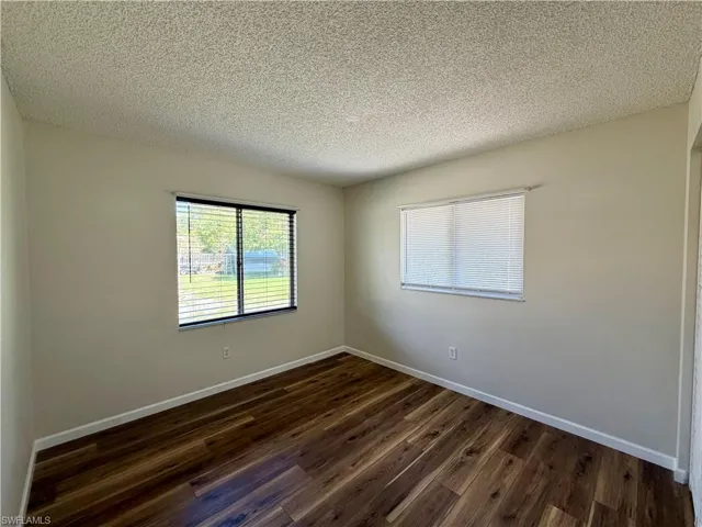 Spare room with dark wood finished floors and a textured ceiling