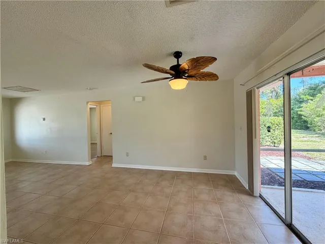 Unfurnished room with a ceiling fan and a textured ceiling
