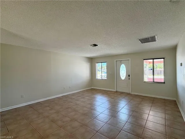 Entrance foyer featuring a textured ceiling and light tile patterned flooring