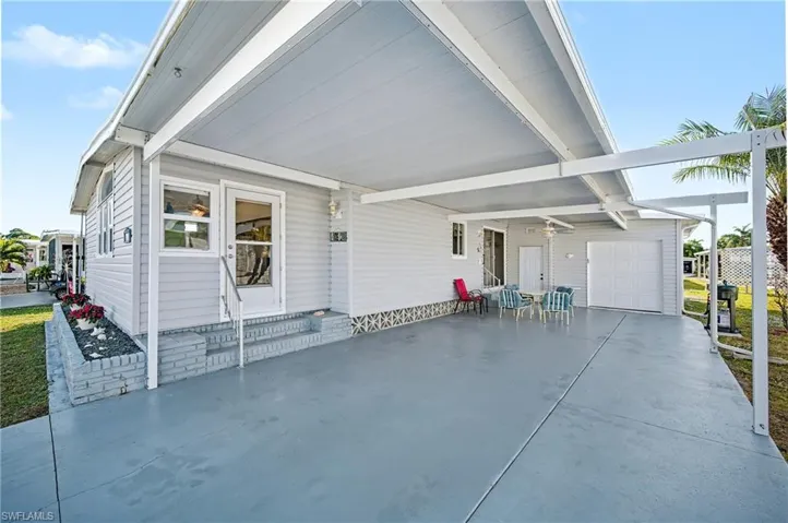 View of patio / terrace featuring an attached carport, a garage, and driveway