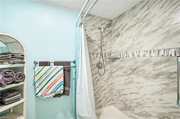 Full bathroom featuring a stall shower and ornamental molding