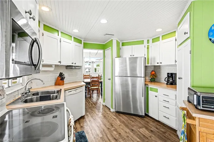 Kitchen featuring white cabinetry, appliances with stainless steel finishes, plenty of natural light, recessed lighting, and wood ceiling