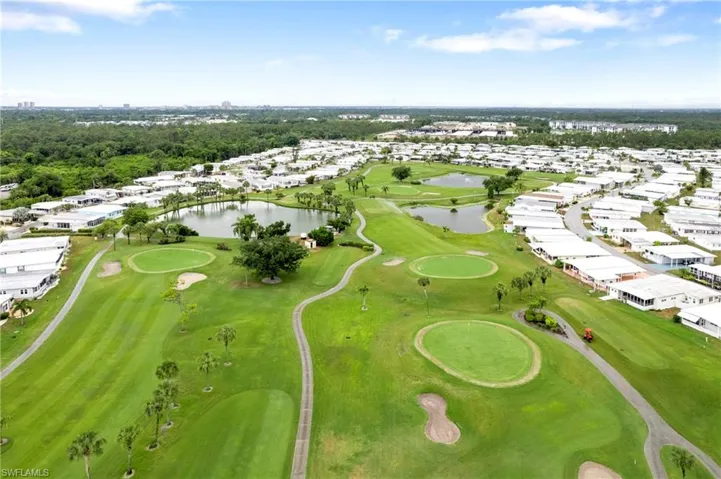 Aerial view of residential area featuring a local golf course and a nearby body of water