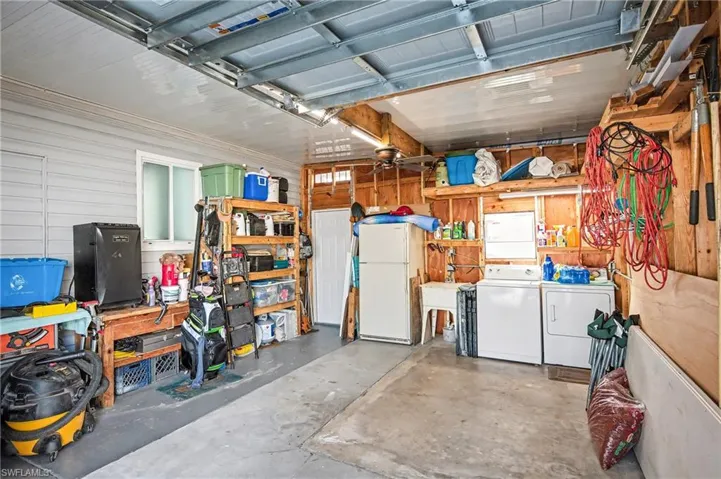 Garage with freestanding refrigerator and washer and clothes dryer