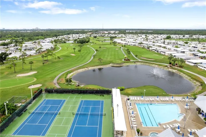 Aerial perspective of suburban area featuring a nearby body of water and a golf club