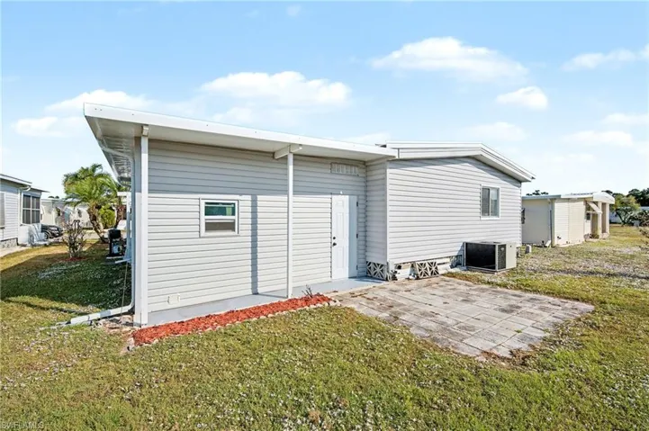 Back of property with a lawn and a patio