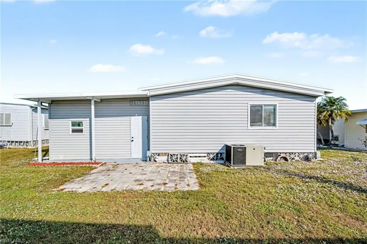 Rear view of property with a patio area and a lawn