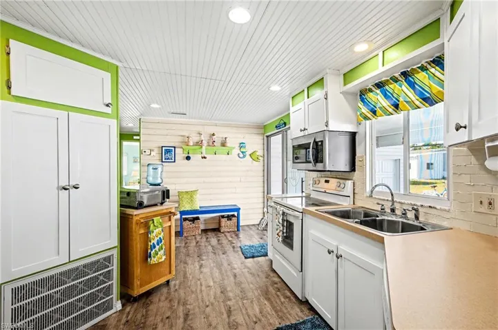 Kitchen with white cabinets, white electric range, stainless steel microwave, dark wood-type flooring, and wood ceiling