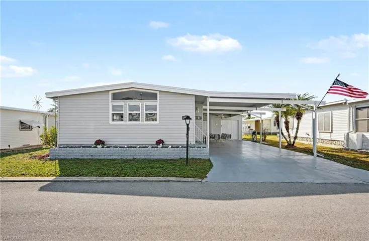 Manufactured / mobile home featuring a carport and driveway