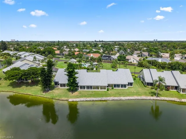 Expansive waterfront property featuring a manicured lawn and mature landscaping