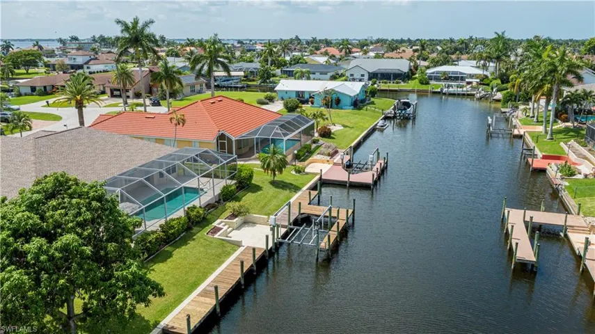 Waterfront property featuring a private boat dock, boat lift, and screened swimming pool