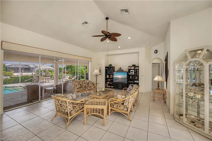 Spacious living area featuring large format tile flooring and vaulted ceilings