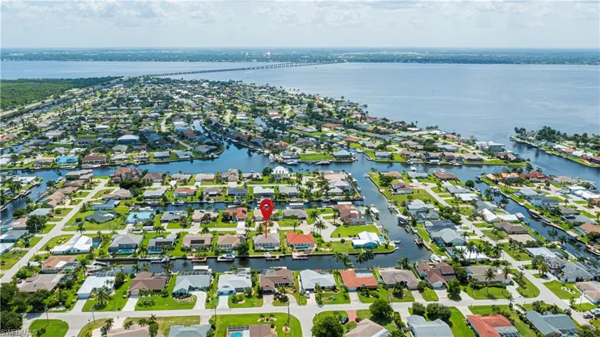 Waterfront residential community featuring a network of canals, direct access to a broad body of water, lush green landscaping, and numerous properties with private docks