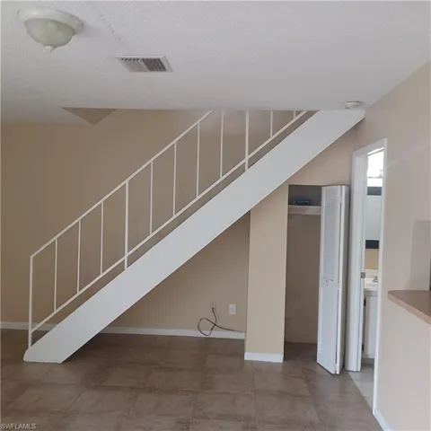 Unfurnished living room with a textured ceiling and baseboards