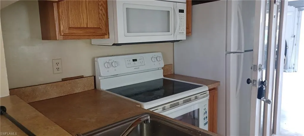 Kitchen with white appliances and brown cabinets