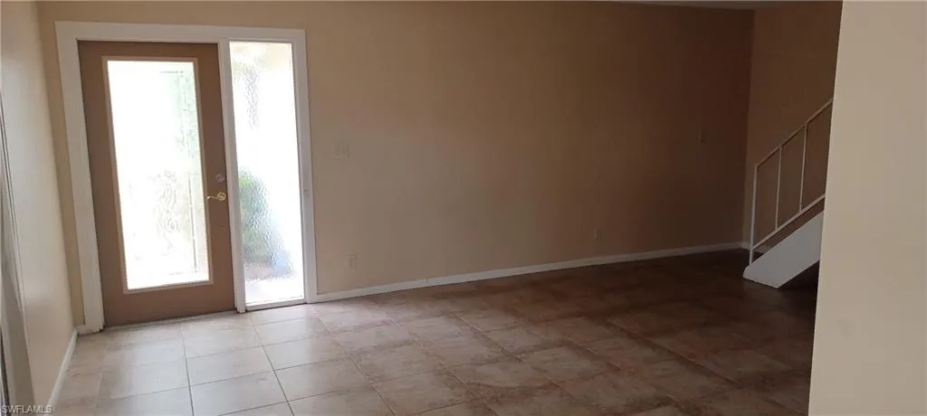 Spare room with baseboards and stairway