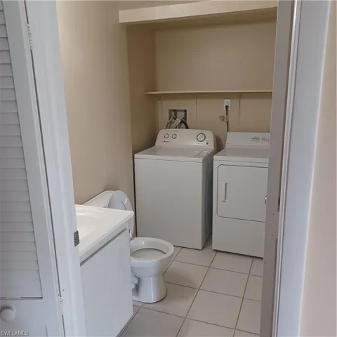 Half bath featuring separate washer and dryer, tile patterned floors, and vanity