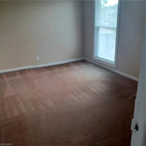 Carpeted spare room with baseboards