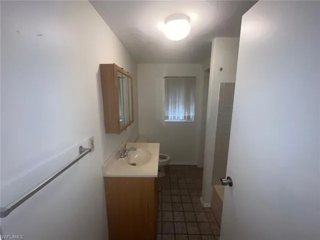 Full bathroom featuring tile patterned flooring, bathtub / shower combination, toilet, and vanity