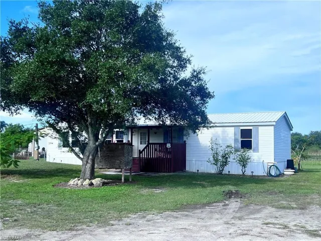 Manufactured / mobile home with a front lawn, a metal roof, and a porch