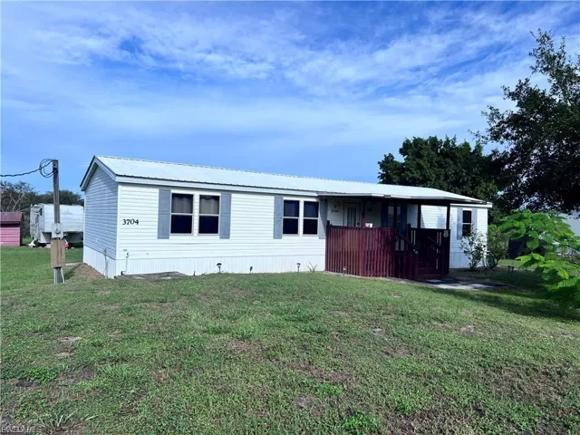 Manufactured / mobile home featuring a front lawn and a metal roof