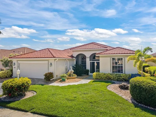 Mediterranean / spanish home with stucco siding, a tile roof, and a front lawn