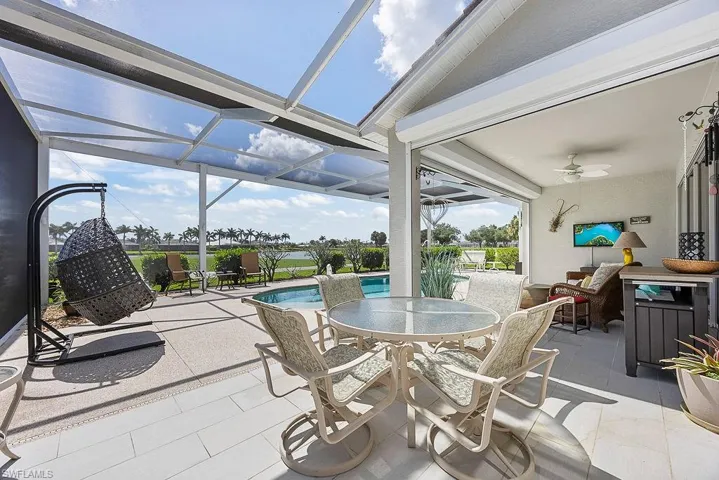 View of patio / terrace with a ceiling fan, outdoor dining area, glass enclosure, and an outdoor pool