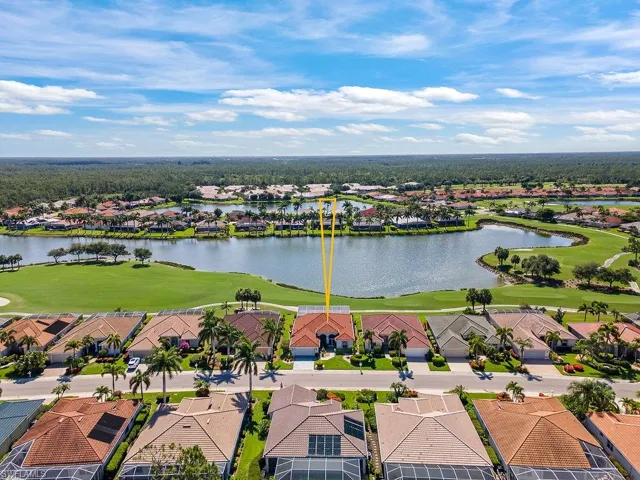 Aerial view of residential area with a nearby body of water and a local golf course