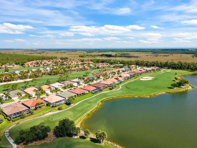 Aerial view of residential area featuring a large body of water and a golf course