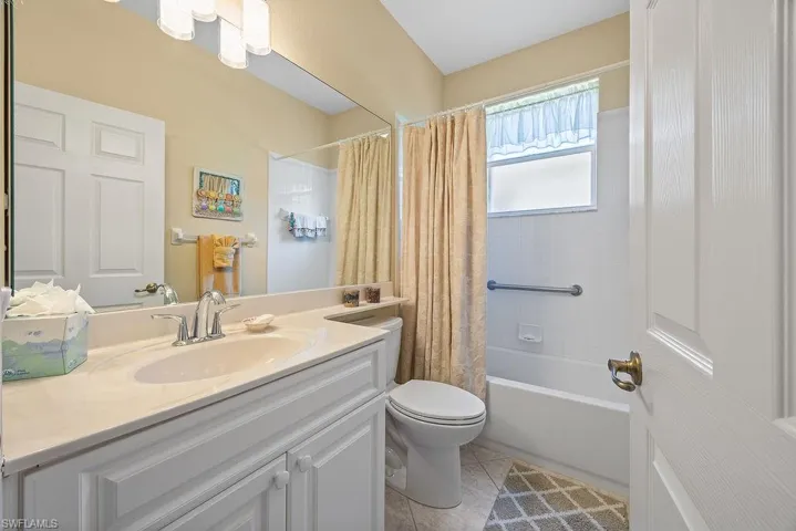 Full bathroom featuring vanity, shower / tub combo, and tile patterned flooring