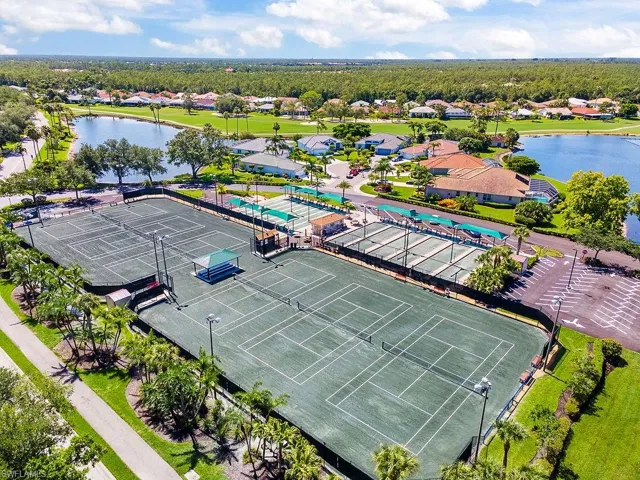 Aerial perspective of suburban area featuring a nearby body of water and a pool area