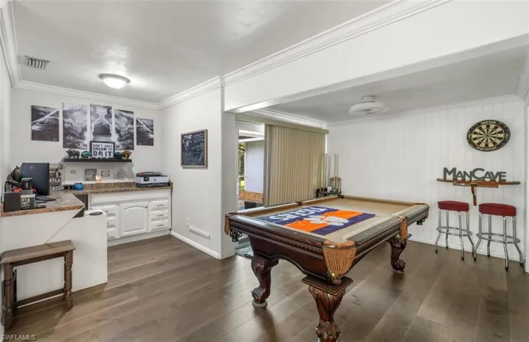 Recreation room featuring pool table, ornamental molding, and dark hardwood / wood-style floors