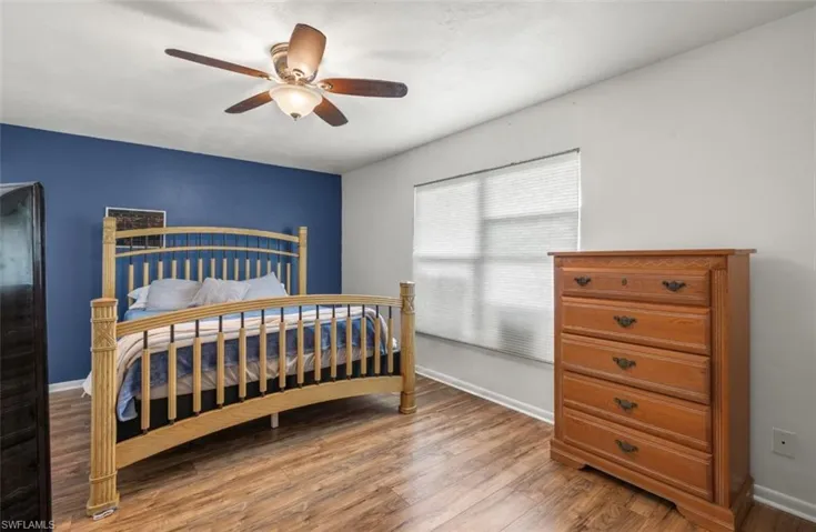 Bedroom with hardwood / wood-style floors and ceiling fan