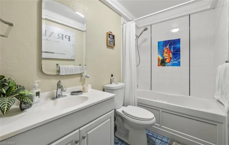 Full bathroom featuring tile patterned flooring, shower / bathtub combination with curtain, toilet, and vanity