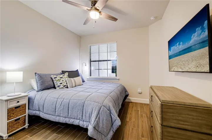 Bedroom with ceiling fan and dark hardwood / wood-style floors