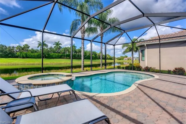 View of swimming pool featuring an in ground hot tub, glass enclosure, and a patio area