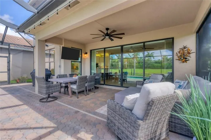 View of terrace with glass enclosure, an outdoor living space, and ceiling fan