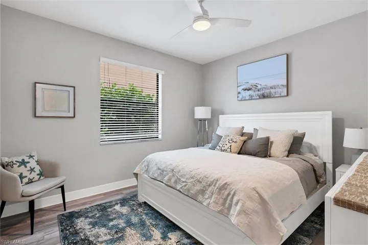 First floor Bedroom with ceiling fan and dark wood-type flooring