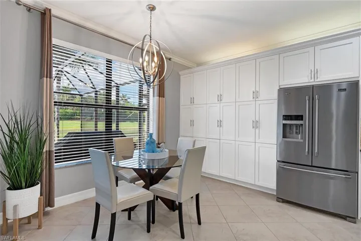 Tiled dining space featuring an inviting chandelier and ornamental molding